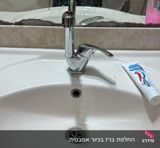 ברז כיור עם משחת שיניים על השיש